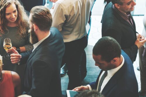 A group of people socializing at an association event and conversing with new members.