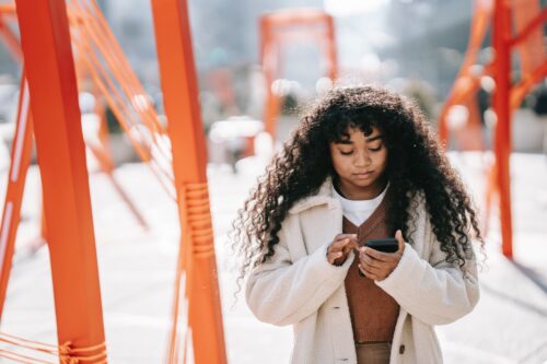 Conference attendee looks down at her phone to consult an event app.